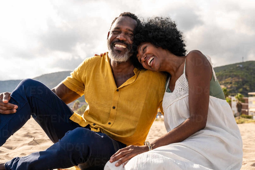 Mature Black Couple in Love Sitting on the Shore